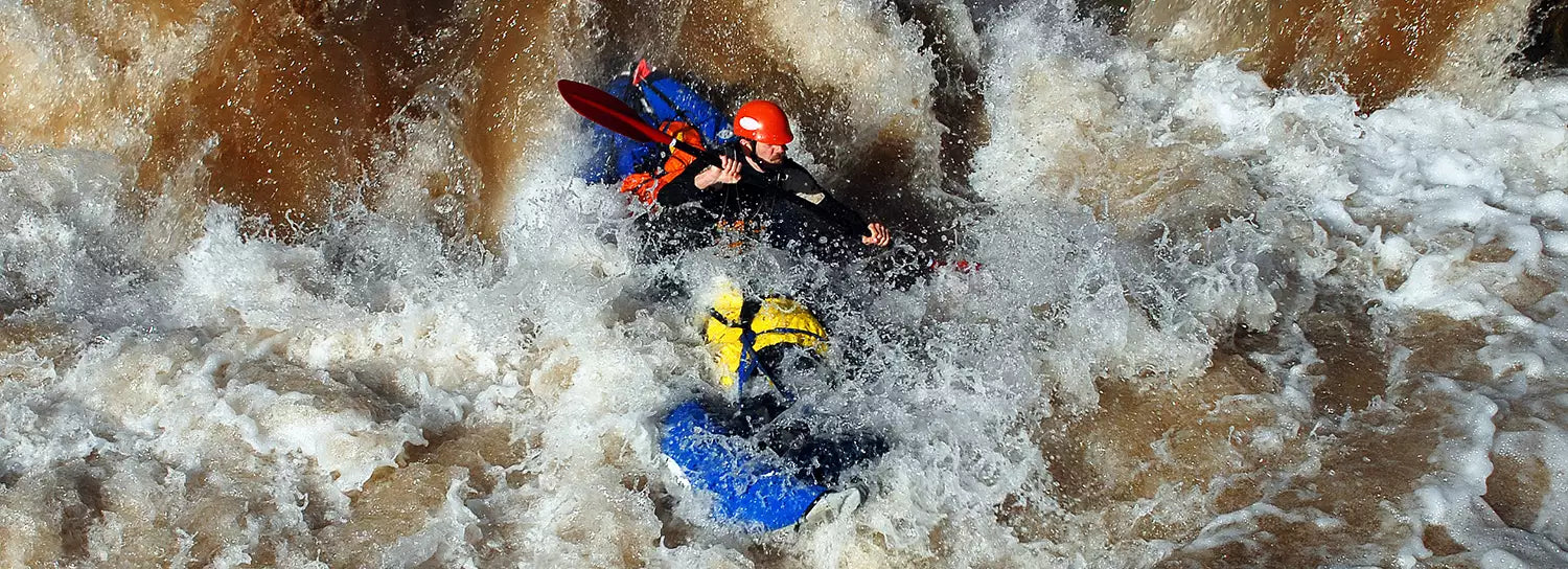 A group of people in a kayak on a river.